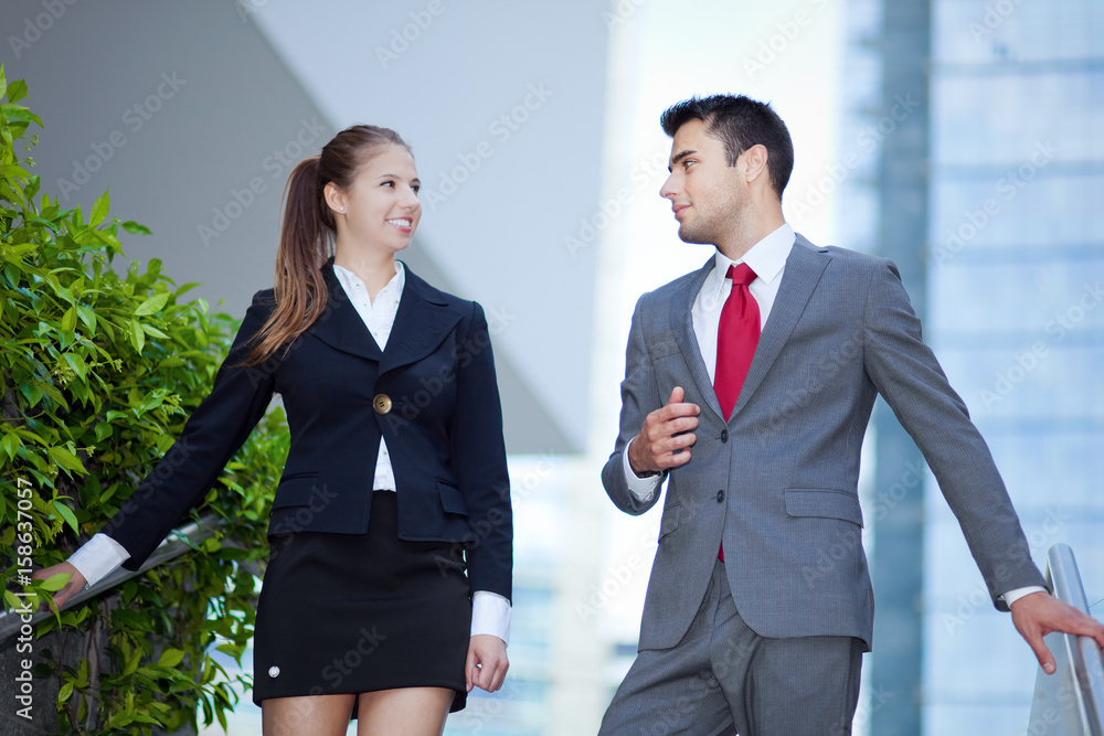 Business partners discussing while on the stairs Business partners discussing while on the stairs