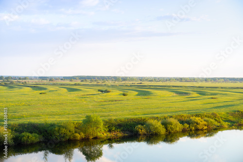 Green field on the river bank © Alex Kor