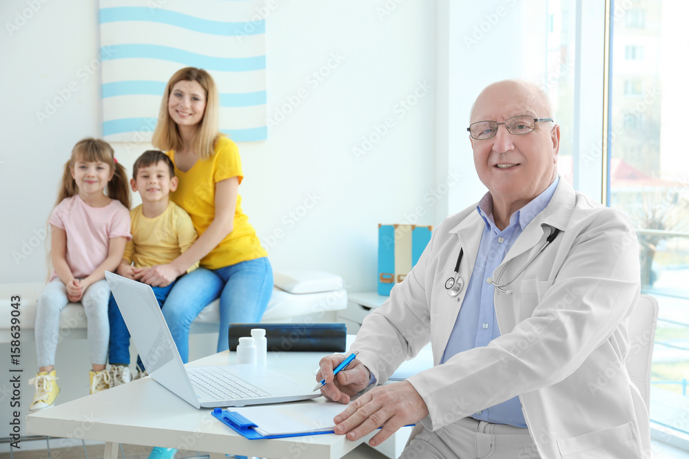Fototapeta premium Elderly orthopedist with patients in his office