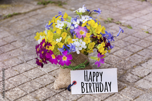 bouquet of spring flowers with happy birthday card