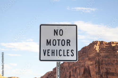 A black and white no motor vehicles sign
