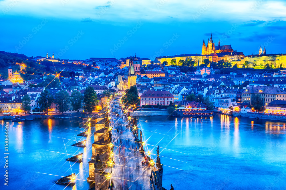 View of Charles Bridge, Prague Castle and Vltava river in Prague, Czech Republic during blue hour. Star filter effect