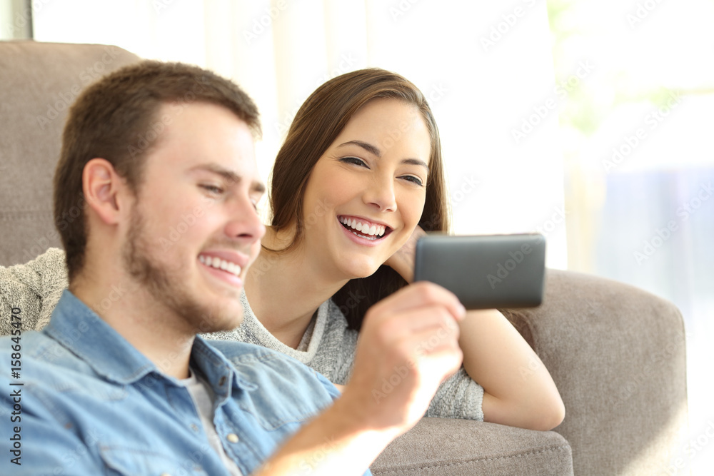 Couple watching media content in a smart phone Couple watching media content in a smart phone