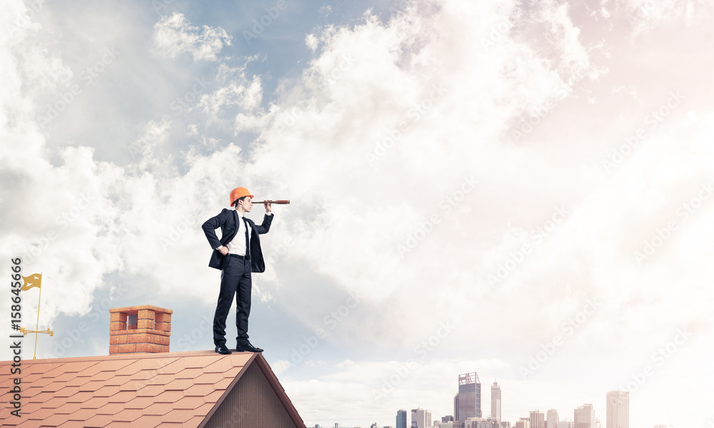 Engineer man standing on roof and looking in spyglass. Mixed med Engineer man standing on roof and looking in spyglass. Mixed med