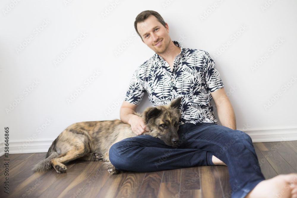 man sitting on floor with his dog