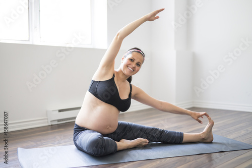 Pregnant woman doing stretching and yoga at home
