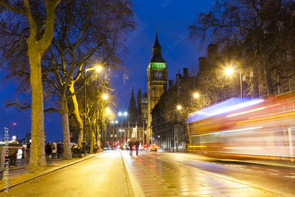 Naklejka premium London cityscape at Big Ben, night scene photo with a red bus and traffic