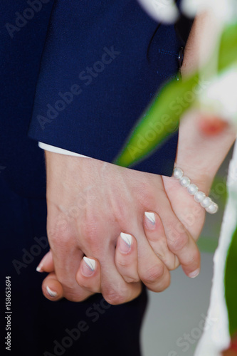 Bride and groom holding hands during wedding ceremony