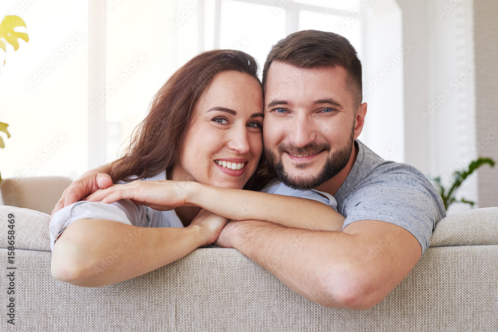 Beautiful woman and man hugging and relaxing on sofa Beautiful woman and man hugging and relaxing on sofa