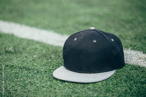 Obraz na płótnie Black cap on grass on natural background