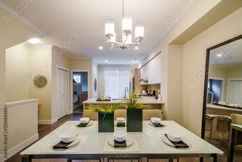 Modern dining room in luxury house with a kitchen in the background. Interior design.