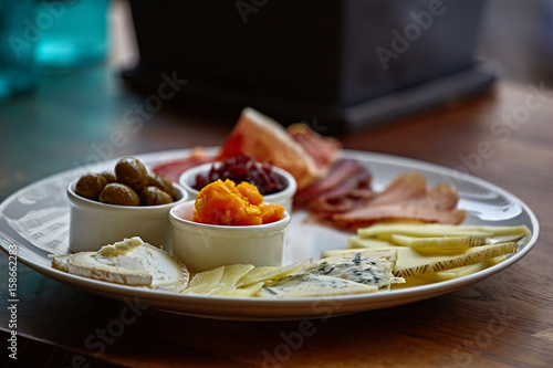 Cheese plate with different kinds of cheese with thyme herbs and walnuts. Mix cheese on wooden board with grapes. Top view..