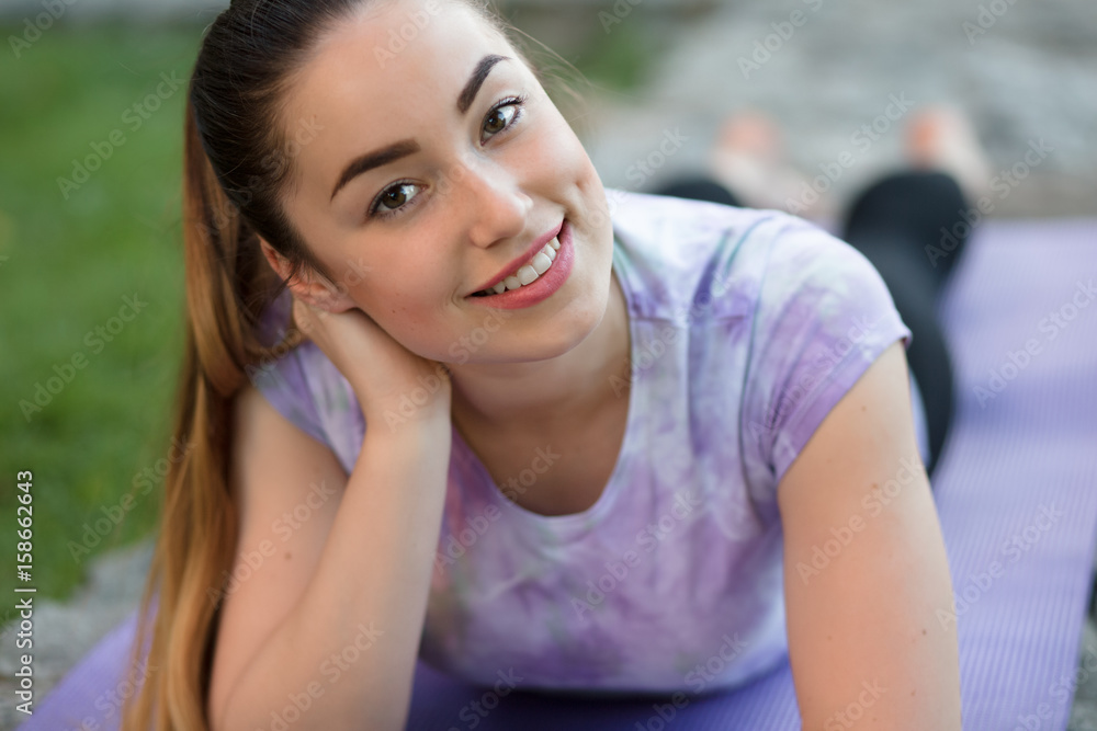Woman on a sportive mat lying relaxing outdoor Woman on a sportive mat lying relaxing outdoor