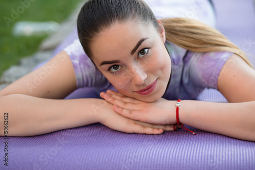 Woman on a sportive mat lying relaxing outdoor