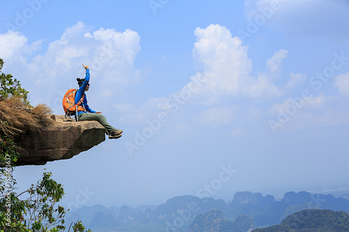 successful woman hiker thinking on mountain peak cliff © lzf