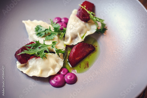 Dumplings and parsley - russian pelmeni - italian ravioli - isolated on white with clipping path. Russian national ravioli with dill on a plate.