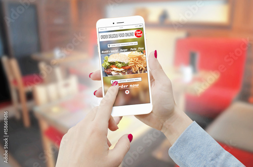 Close-up of a female hands ordering food with a phone in restaurant. Food order concept