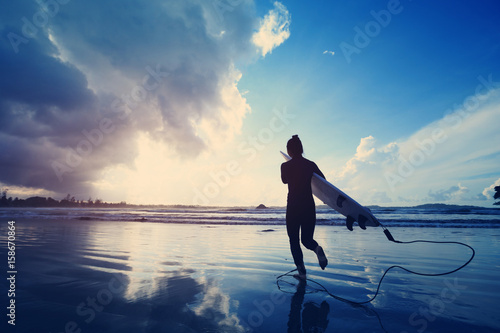 Canvas Print young woman surfer ready to surf on a beach