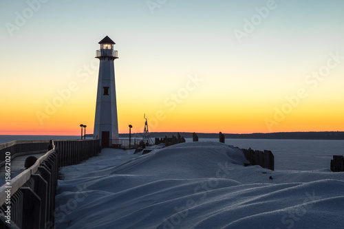 Winter Coastal Sunrise. Winter sunrise on the frozen shores of the Great Lakes with Wawatam Lighthouse in the St. Ignace harbor in Michigan's Upper Peninsula. 
