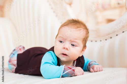 Portrait of a cute newborn baby lying on its stomach and smiling