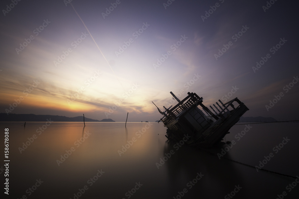 Sinking boat during sunrise