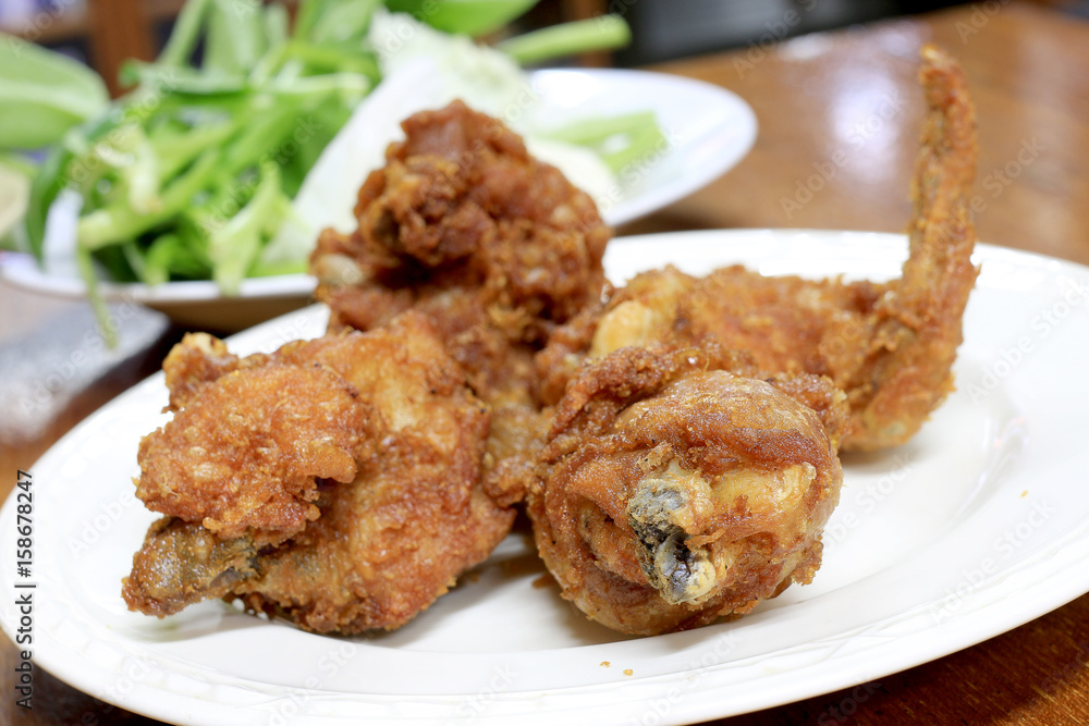 Spicy Deep Fried Breaded Chicken Wings in white dish on the table for dinner.