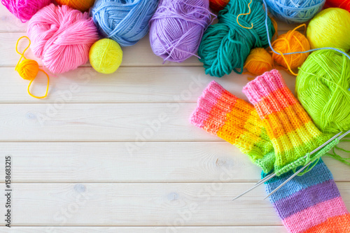 Fototapeta Closeup of basket with colorful yarn clews. Knitted Socks.