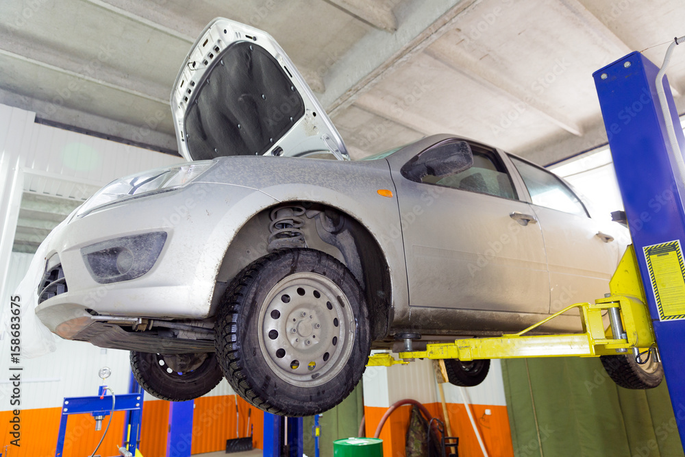 Fototapeta premium The car on the lift. Change engine oil and transmission inspection
