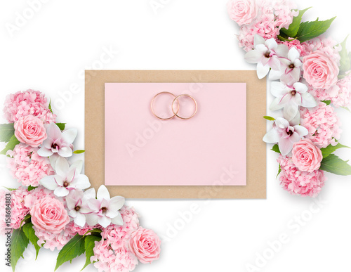 Roses, magnolia, hortensia and bridal rings with paper greeting card for wedding