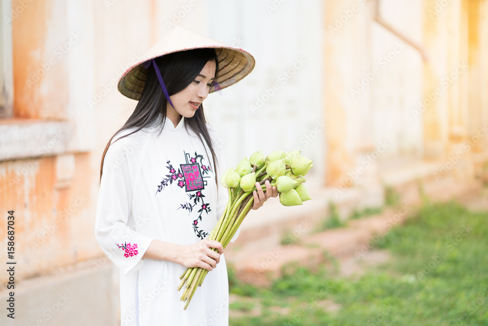 beautiful woman with Vietnam culture traditional dress, Ao dai and  holding lotus