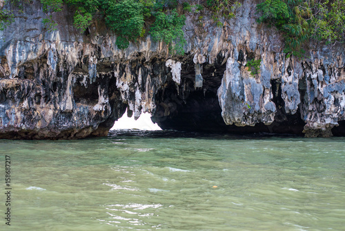 Cave,Tourists kayaking through limestone cliffs in Phang-nga Bay of Thailand