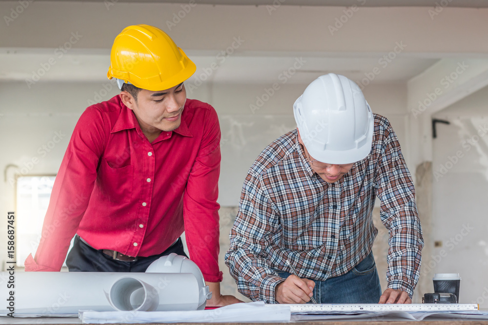 Group of engineer checking the blueprint on the table and talking about construction project with commitment to success at construction site Group of engineer checking the blueprint on the table and talking about construction project with commitment to success at construction site