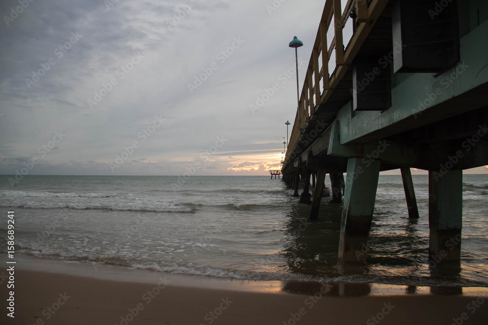 Pier on the beach with cloudy sky in morning Pier on the beach with cloudy sky in morning