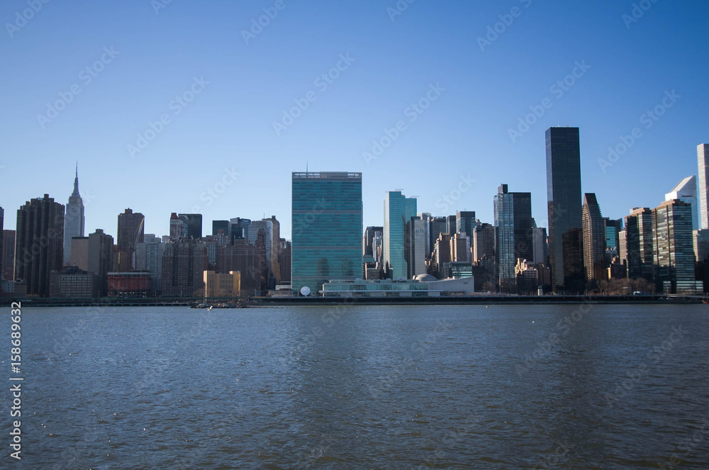 Buildings over river with blue sky, New York