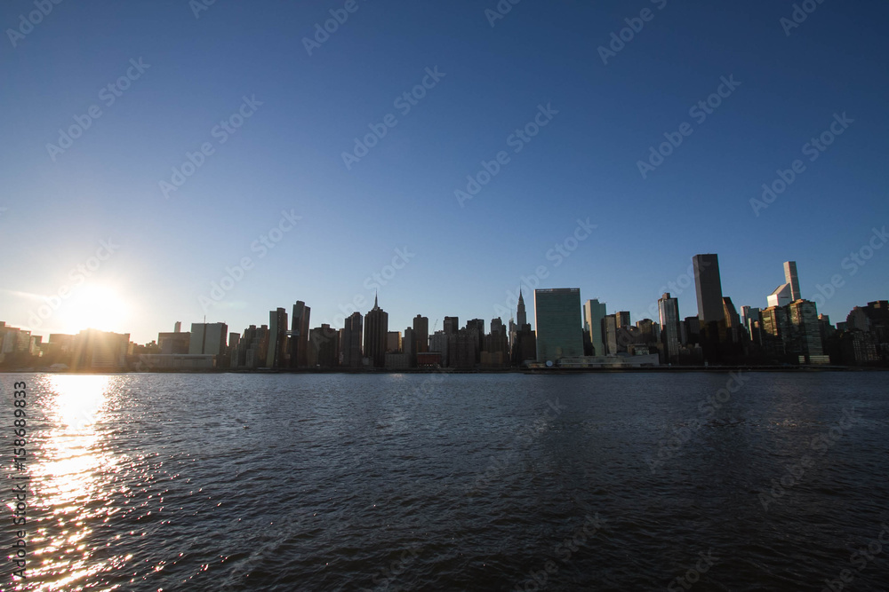 Manhattan city under the shade and East river with sunset