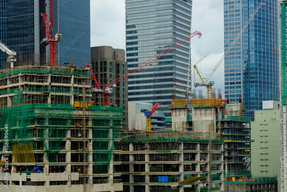Construction cranes at top of unfinished buildings Construction cranes at top of unfinished buildings