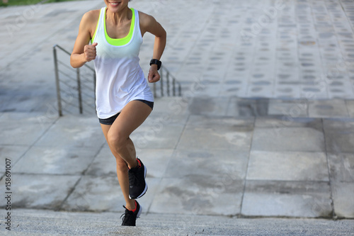 young fitness sports woman running up on stone stairs