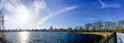 Lake at Central Park and buildings in Manhattan under the sun in panorama
