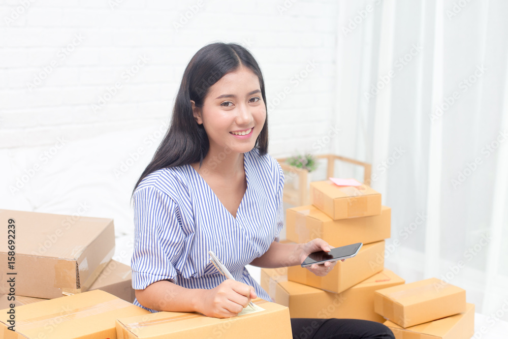 Young asian woman business owner work and white down address for deliver at home, woman business owner concept, 20-25 year old.. Young asian woman business owner work and white down address for deliver at home, woman business owner concept, 20-25 year old..