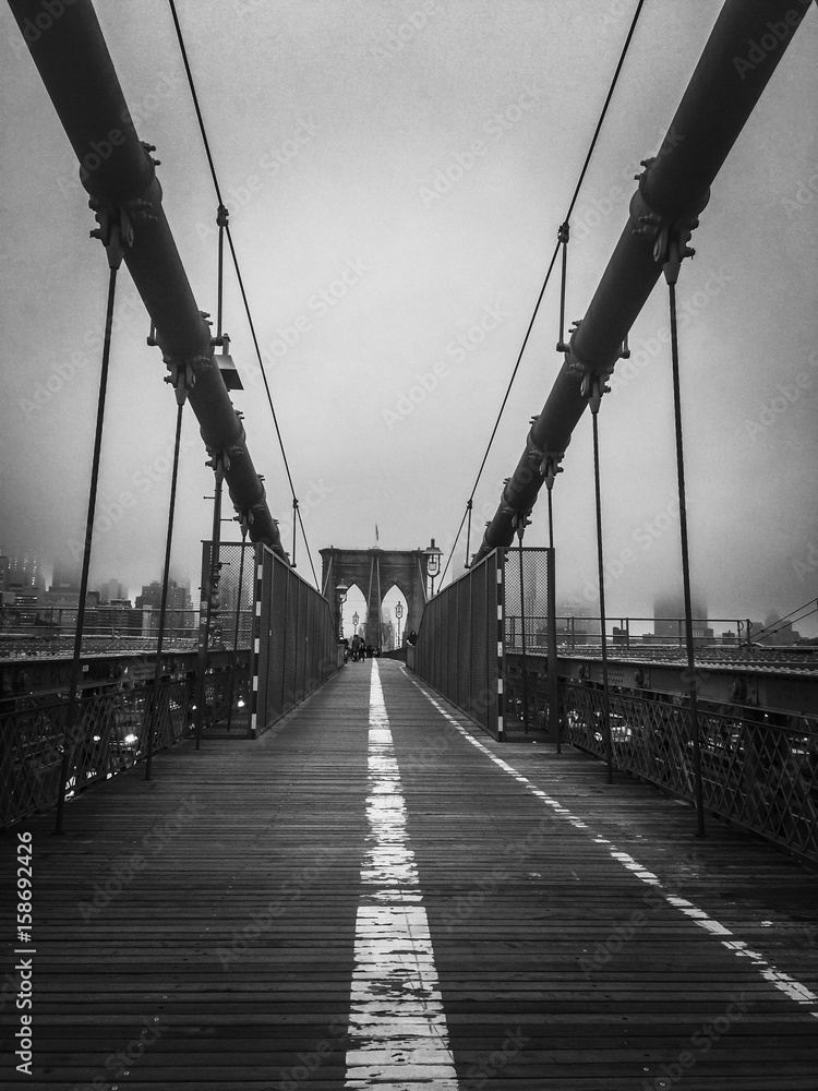 Obraz premium Przejście przy mostem brooklyńskim z mgłowym w czarny i biały stylu