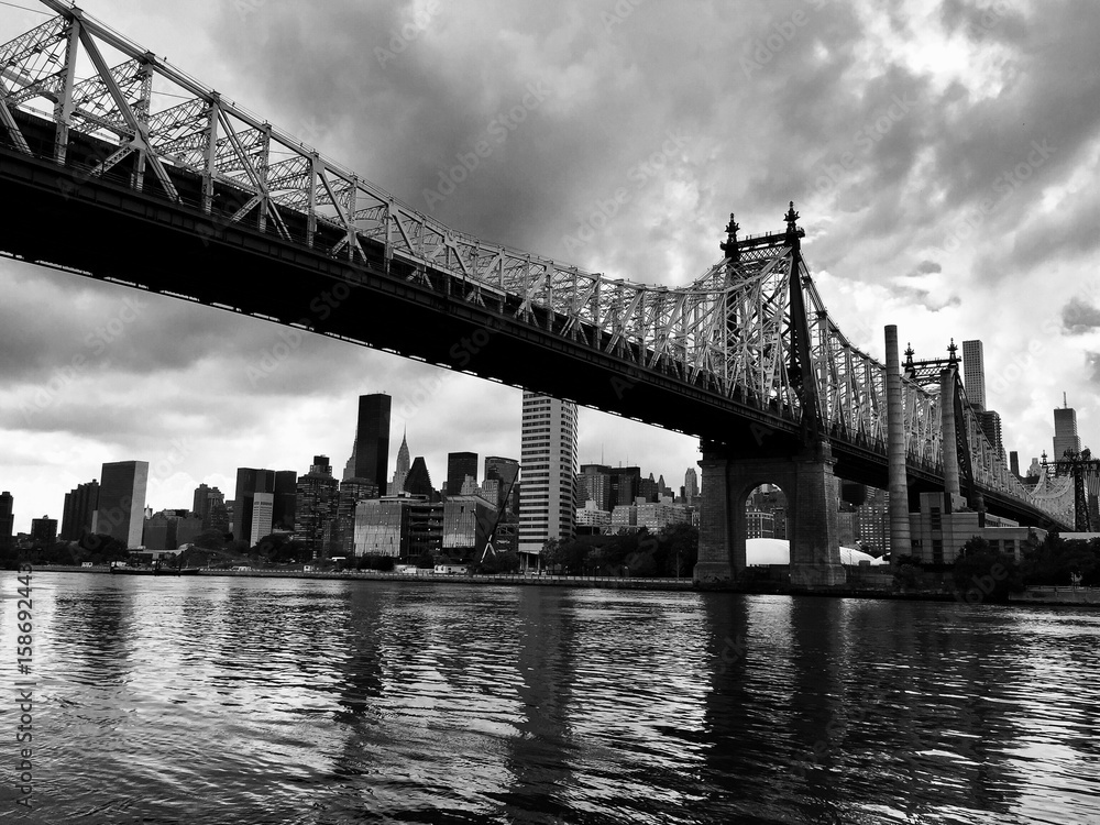 Queensboro bridge over the river and buildings in black and white style, New York