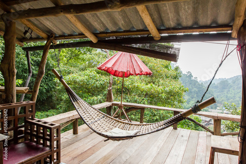 Empty wooden hammock outside the terrace with jungle background in Chiang Mail, Thailand