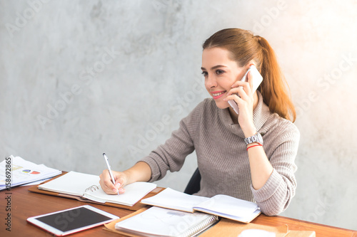 Young woman using smartphone for work at modern place, Business people takling in modern office. Greeting deal concept photo