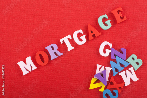 MORTGAGE word on red background composed from colorful abc alphabet block wooden letters, copy space for ad text. Learning english concept.