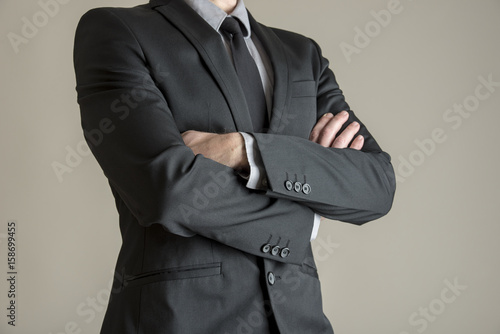 Obraz na plátne Torso of a businessman standing with folded arms