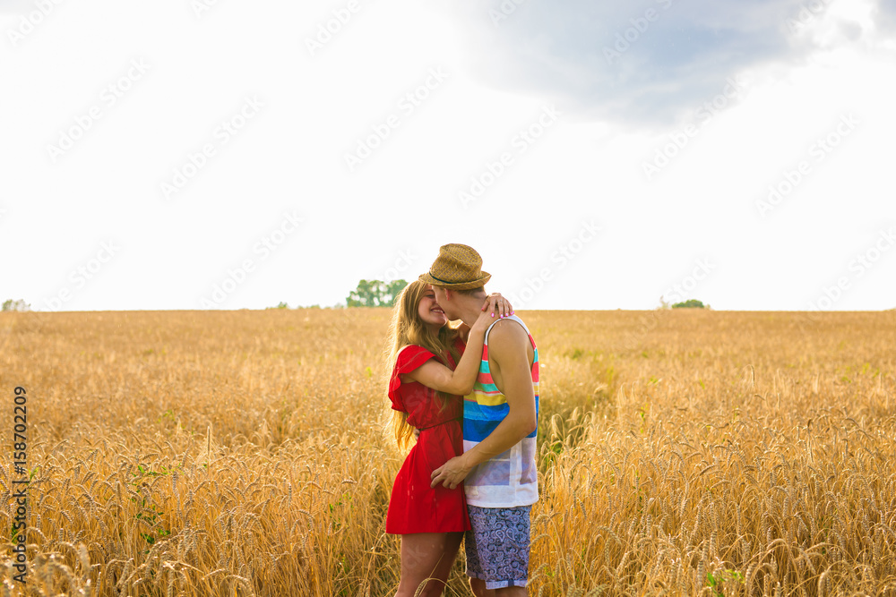 Young love couple kissing on field in sunlight Young love couple kissing on field in sunlight