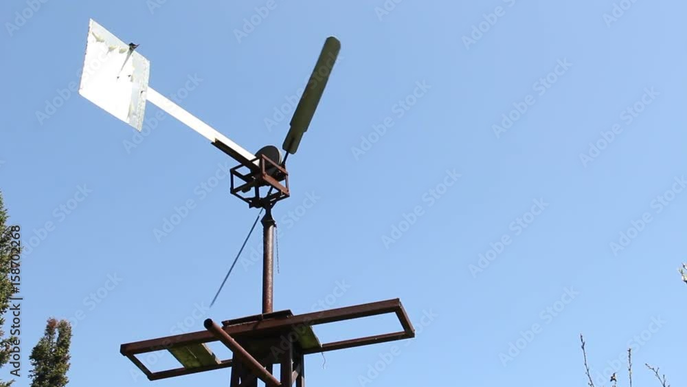 The windmill pumped water in Siberia against the blue sky. The windmill pumped water in Siberia against the blue sky.