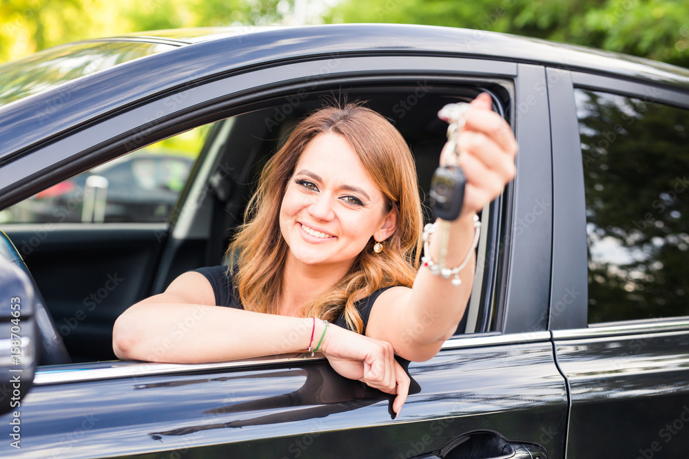 Beautiful young woman driver showing car keys in hand Beautiful young woman driver showing car keys in hand