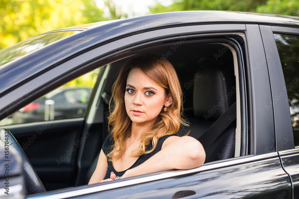 Portrait of smiling young woman driving a car