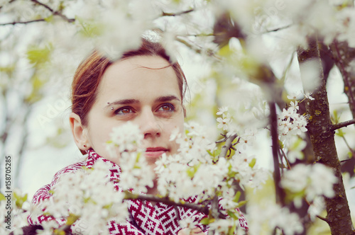 Beautiful woman in spring bloom. Toned picture. The girl has a beautiful face, bright eyes.